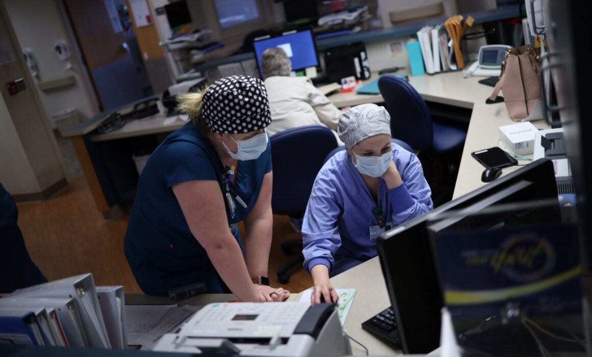 Nurses at a hospital front desk.